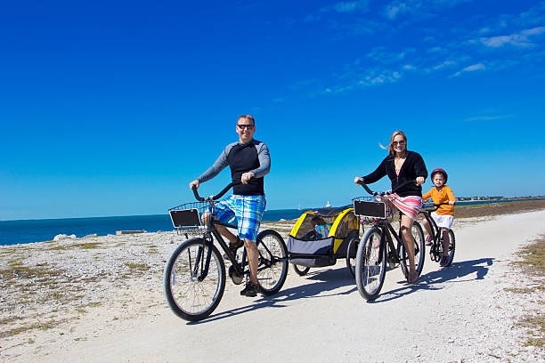 Family enjoying a bike ride along the beach in Charleston, SC, showcasing Carolina Salt’s rental