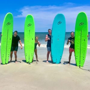family standing on folly beach with surf boards